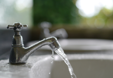 Wasserhahn, aus dem Wasser in ein Waschbecken fließt